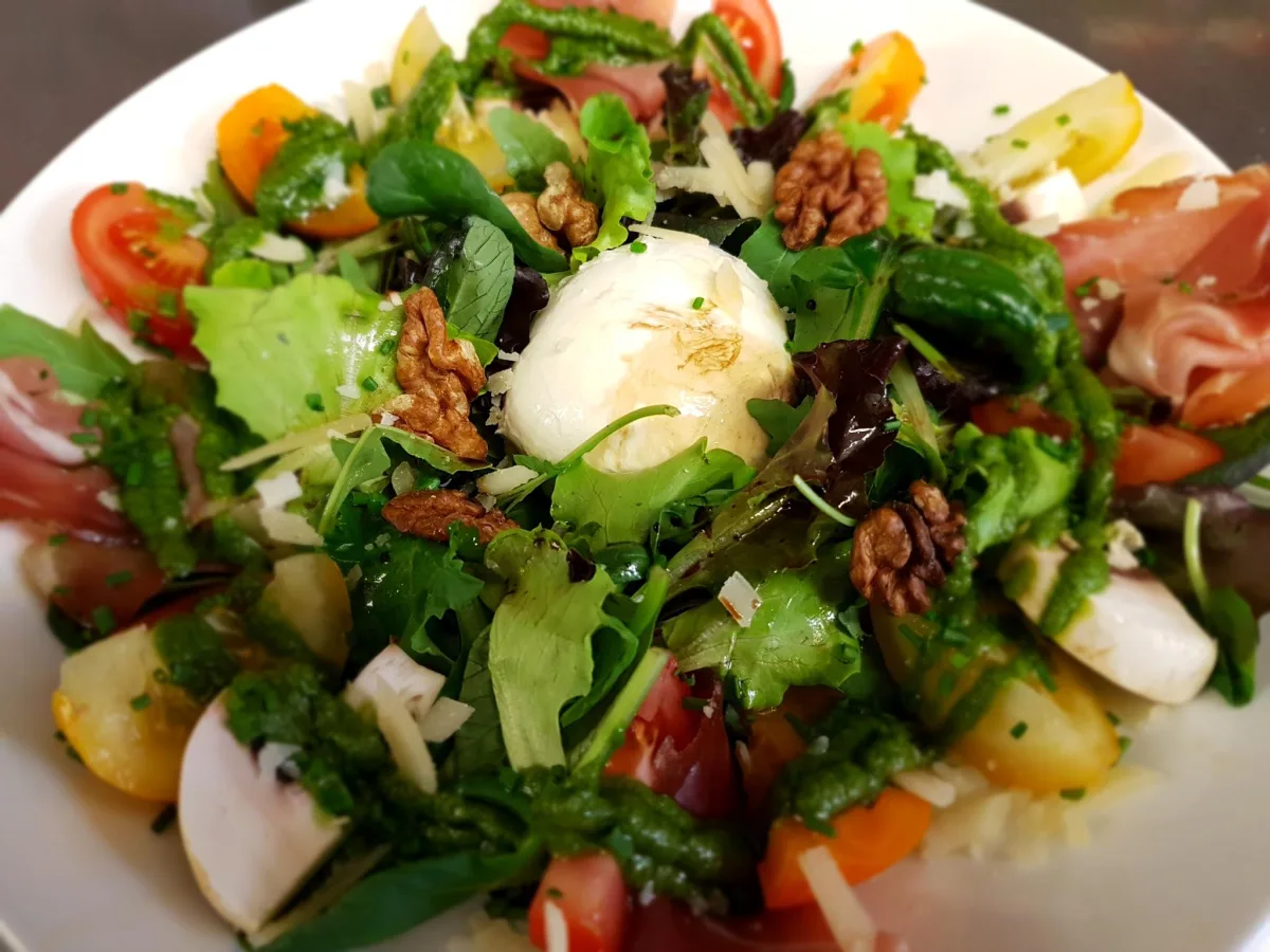 Salade composée aux noix, œuf poché et jambon cru préparée par La Brasserie du Mont Blanc